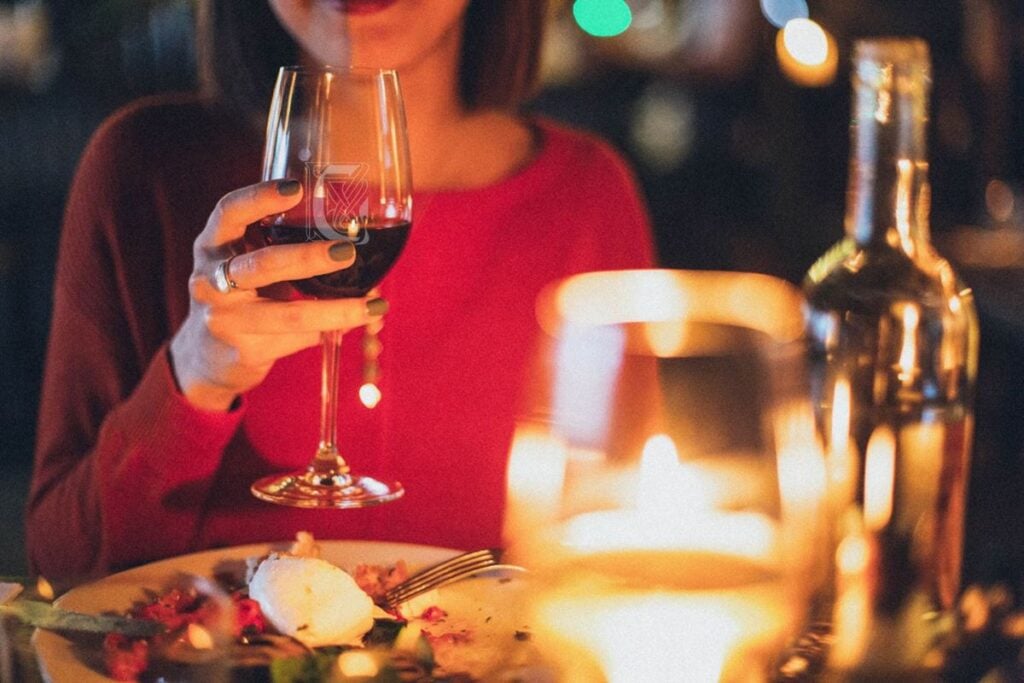 Woman in a red jumper holding a custom engraved glass.