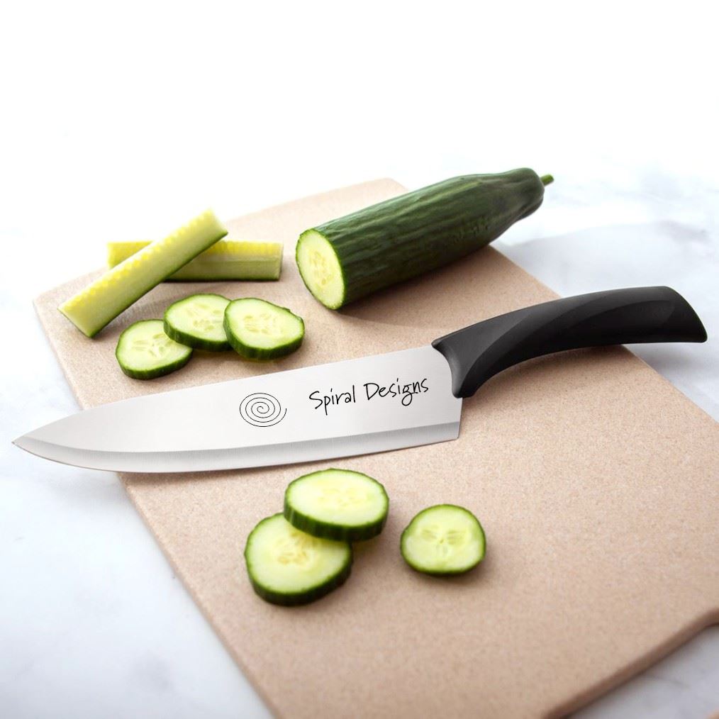 Engraved knife on cutting board with sliced cucumber