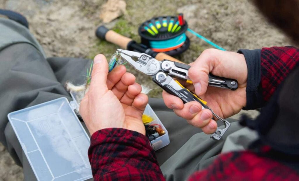 Leatherman signal shown in use holding a fishing hook